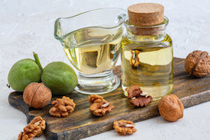 Walnut oil in a bottle and a glass cup.